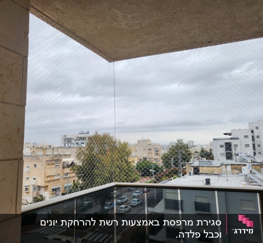 רשת שקופה מותקנת על מרפסת למניעת כניסת יונים